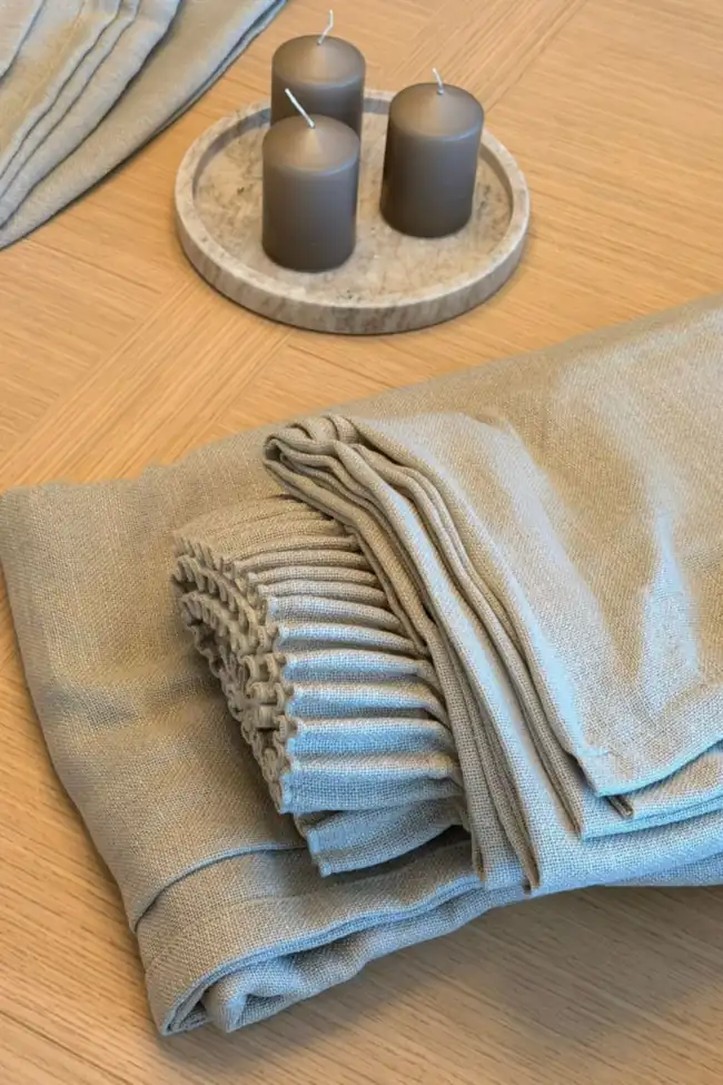 Cortinas confeccionadas a medida, dobladas sobre una mesa antes de la instalación