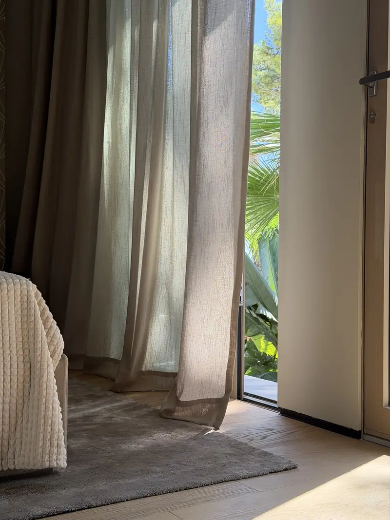 Cortinas de dormitorio junto a la puerta de la terraza con el jardín al fondo