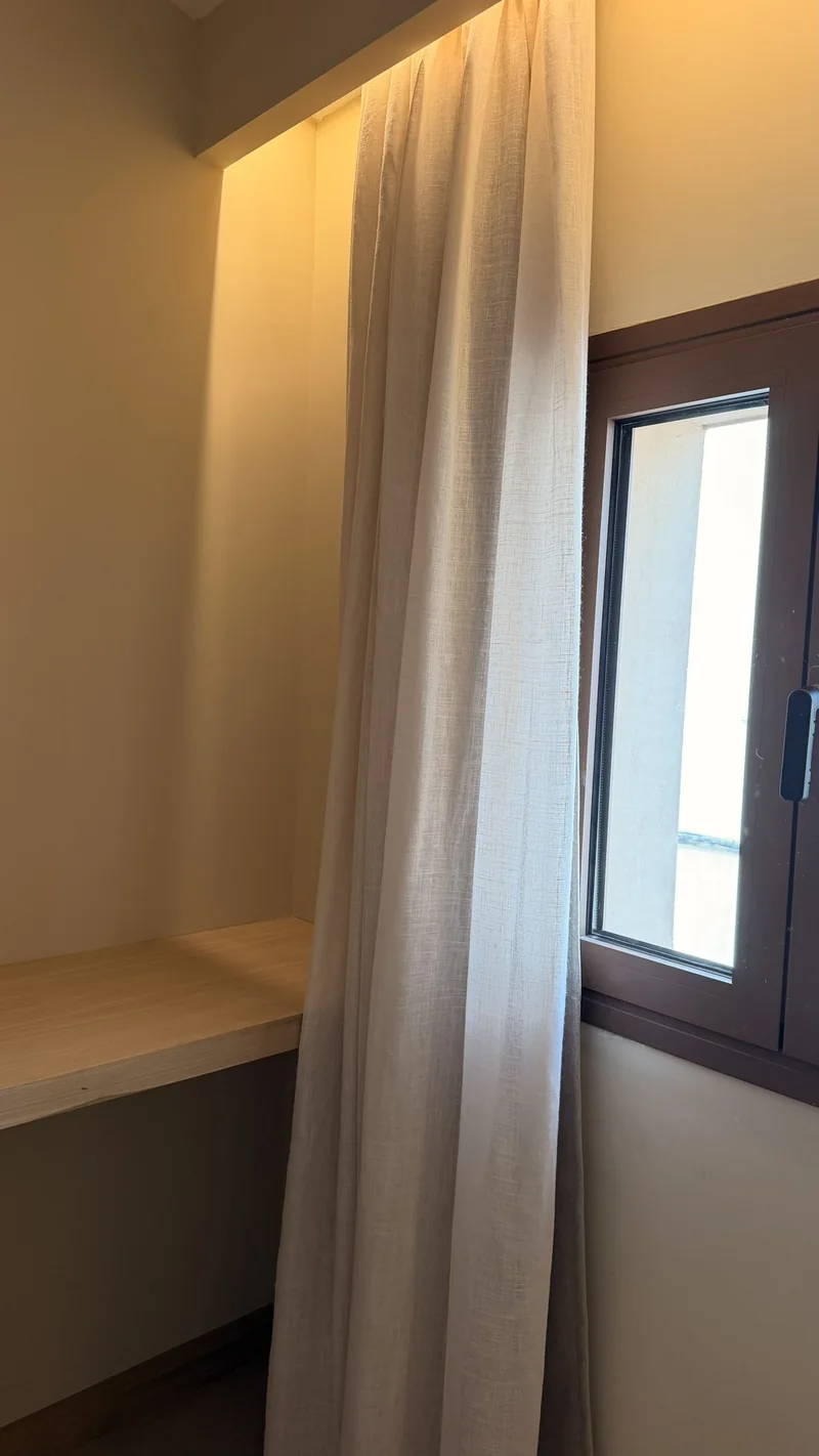 Cortina de lino en mezcla colgada de un foseado con luz junto a la ventana