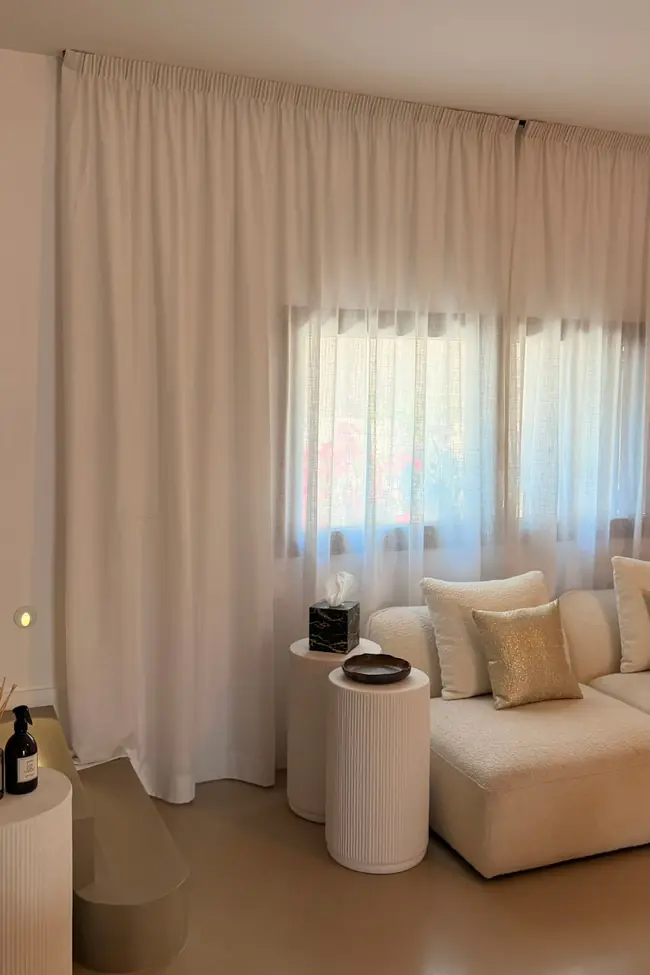 Salón con cortinas blancas de cabezal fruncido de suelo a techo